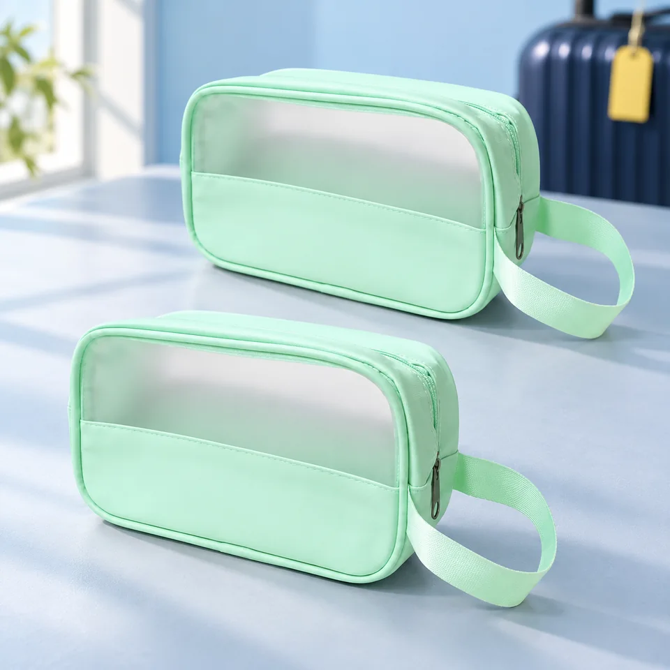 LUFFLOK — deux trousses transparentes vertes de LUFFLOK, mise en situation dans un univers de voyage bleu-gris